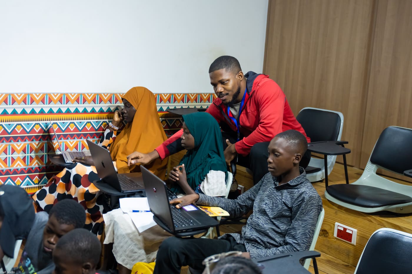 A mentor helping students debug their code